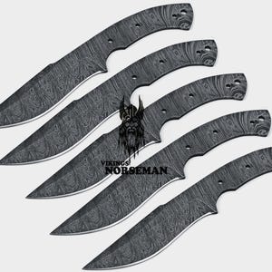 Peut inclure: Cinq lames de couteau en acier Damas noir et argent avec une finition à motifs. Les lames sont disposées en quinconce, la plus grande en haut et la plus petite en bas.