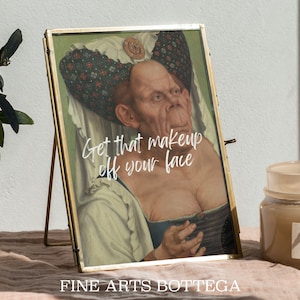 May include: A gold-framed picture of a woman wearing a patterned head covering and a low-cut dress. The text "Get that makeup off your face" is superimposed on the image.
