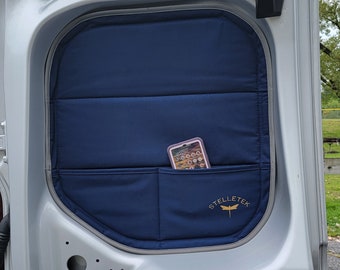 May include: A blue van door panel with a pocket for a phone and the logo "Stelletek" with a dragonfly design.