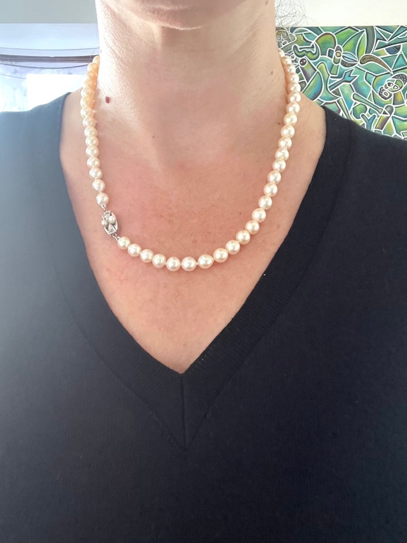 May include: A classic pearl necklace with a silver clasp. The pearls are white and round, and the necklace is approximately 18 inches long.