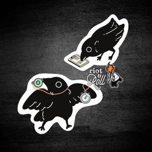May include: Two black crow stickers with white outlines. One crow writes on a clipboard, the other wears a whistle and a stopwatch. The stickers have a dark background with the text "riot & roll".
