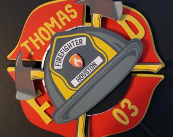 May include: Red, yellow, and black firefighter themed cake topper with the name "THOMAS" and the number "03" on it. The topper also features a firefighter helmet with the words "FIREFIGHTER" and "HOUSTON" on it.