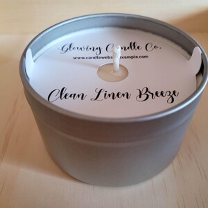 Photo featuring a sample of custom candle dust covers with mockup candle company name, candle ounces and type of wax, scent name Clean Linen Breeze and the standard remove lid before lighting text at the bottom. White cardstock black ink standard wick.
