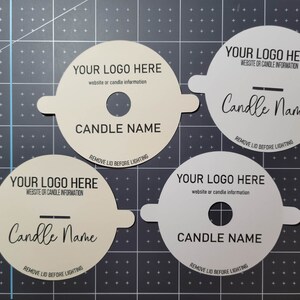 Samples of custom dust covers in cream and white cardstock with black printing. Samples include standard and wood wick options with example text, including Your Logo here.