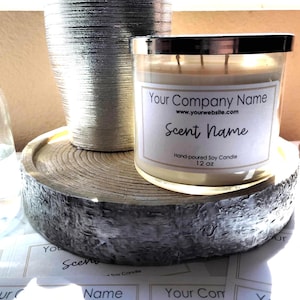 May include: A three-wick candle in a clear glass jar with a silver lid. The white label reads Your Company Name, www.yourwebsite.com, Scent Name, and Hand-poured Soy Candle 12 oz. The candle sits on a round, silver-painted wooden slice base.