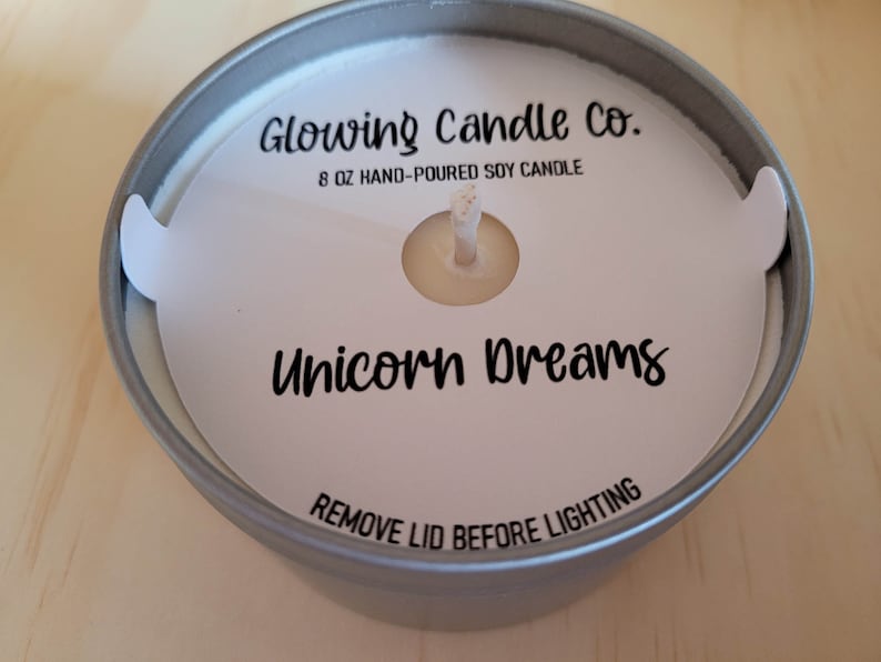 Photo featuring a sample of custom candle dust covers with mockup candle company name, candle ounces and type of wax, scent name Unicorn Dreams and the standard remove lid before lighting text at the bottom. White cardstock black ink standard wick.