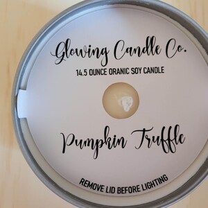 Photo featuring a sample of custom candle dust covers with mockup candle company name, candle ounces and type of wax, scent name Pumpkin Truffle and the standard remove lid before lighting text at the bottom. White cardstock black ink standard wick.