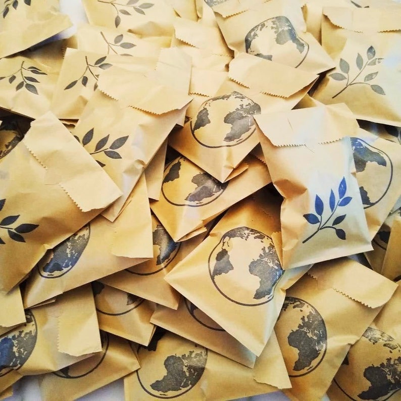 May include: A pile of brown paper bags with a globe and a leaf design printed on them.