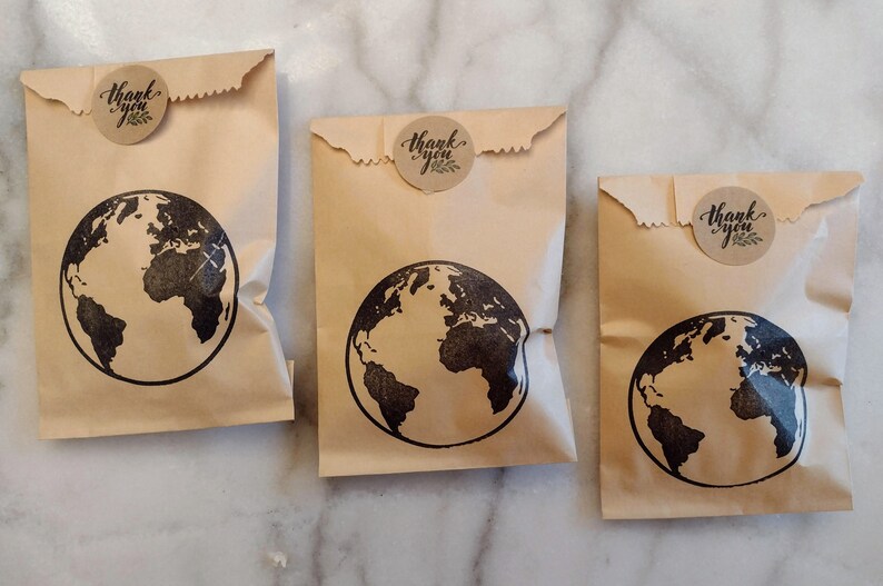 May include: Three brown paper bags with a black globe design and a round brown sticker that says "Thank you".