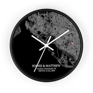 Peut inclure: Horloge noir et blanc avec une carte de Southsea, Portsmouth, Royaume-Uni. Le cadran de l'horloge pr&eacute;sente un c&oelig;ur rouge marquant un emplacement. Le texte "Sophie & Matthew" est imprim&eacute; sous la carte, ainsi que la date et l'heure "3:00 P.M. 14. Jan. 2018".