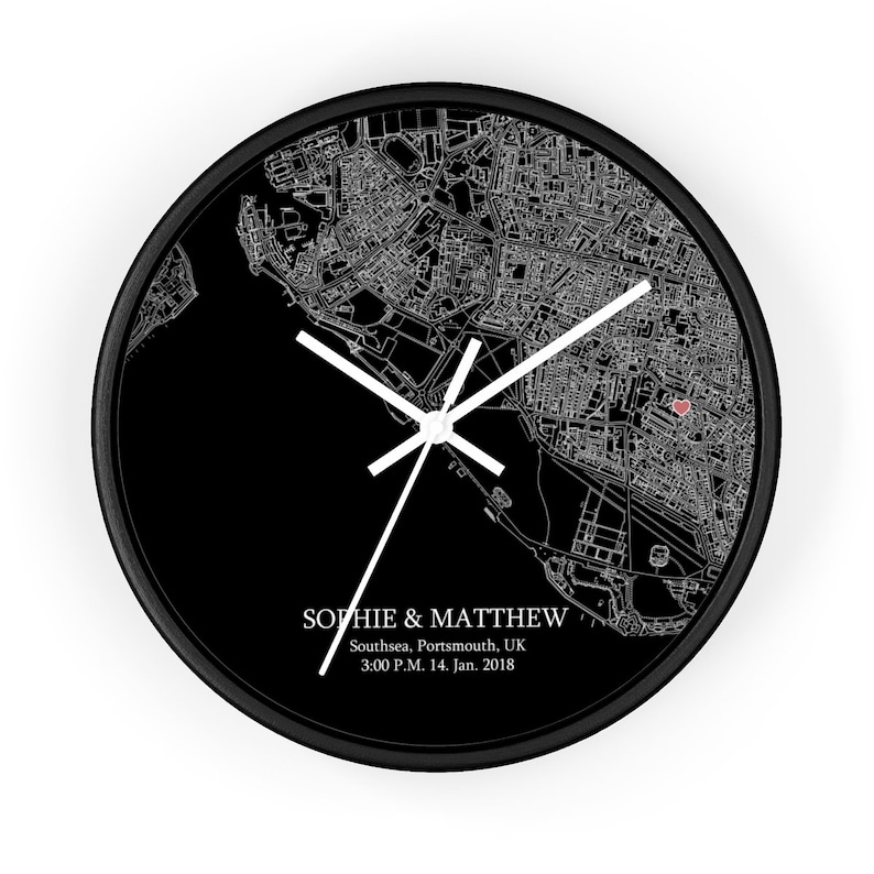 Peut inclure: Horloge noir et blanc avec une carte de Southsea, Portsmouth, Royaume-Uni. Le cadran de l'horloge pr&eacute;sente un c&oelig;ur rouge marquant un emplacement. Le texte "Sophie & Matthew" est imprim&eacute; sous la carte, ainsi que la date et l'heure "3:00 P.M. 14. Jan. 2018".