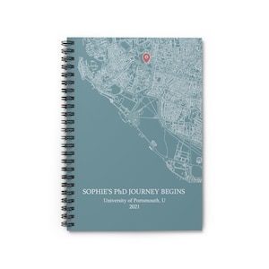 Puede incluir: Una libreta de espiral azul con un mapa de Portsmouth, Reino Unido, y el texto "SOPHIE'S PHD JOURNEY BEGINS University of Portsmouth, UK 2021".