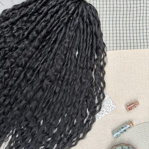 May include: A collection of long, black, wavy hair extensions featuring a twisted texture. The strands are arranged in a dense, flowing mass, showcasing a consistent dark color and a defined, crimped wave pattern throughout the entire length.