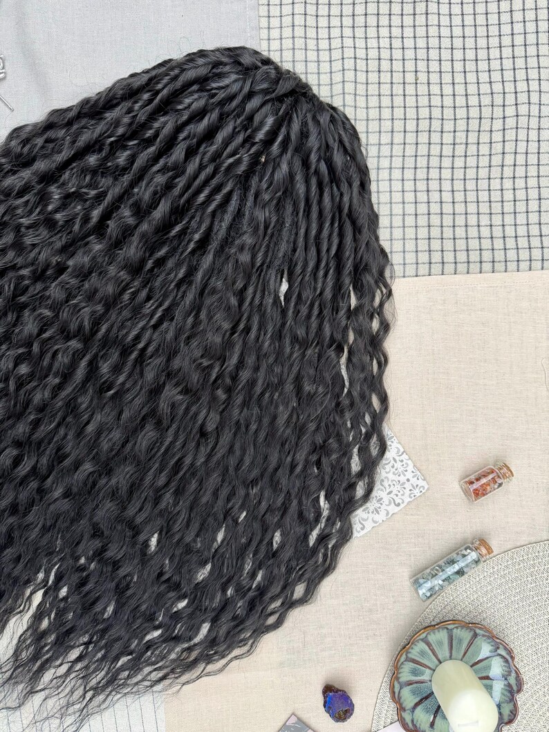 May include: A collection of long, black, wavy hair extensions featuring a twisted texture. The strands are arranged in a dense, flowing mass, showcasing a consistent dark color and a defined, crimped wave pattern throughout the entire length.
