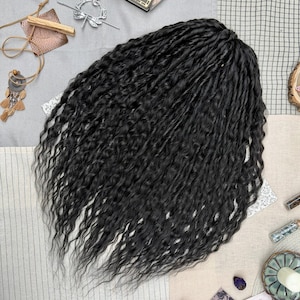 May include: A set of long, black, wavy synthetic hair extensions with a textured, crimped appearance. The hair is arranged in a dense, voluminous cluster, showcasing a deep black color throughout the strands, which feature a consistent, wavy pattern from the top down to the tapered ends.
