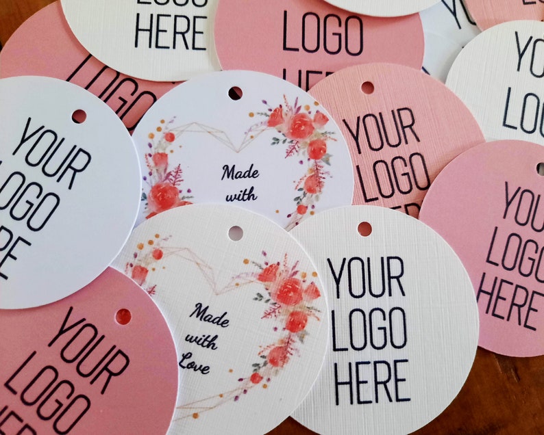 May include: A set of round, pink and white gift tags with the text "Your Logo Here" and floral designs. Some tags also include the text "Made with Love".