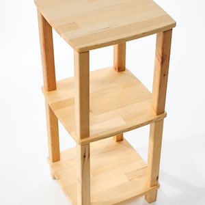 Può includere: Un'unità a scaffale in legno a tre livelli realizzata in legno naturale. Lo scaffale è realizzato in legno massello e ha una finitura naturale. Lo scaffale è perfetto per esporre oggetti o riporre piccoli oggetti.