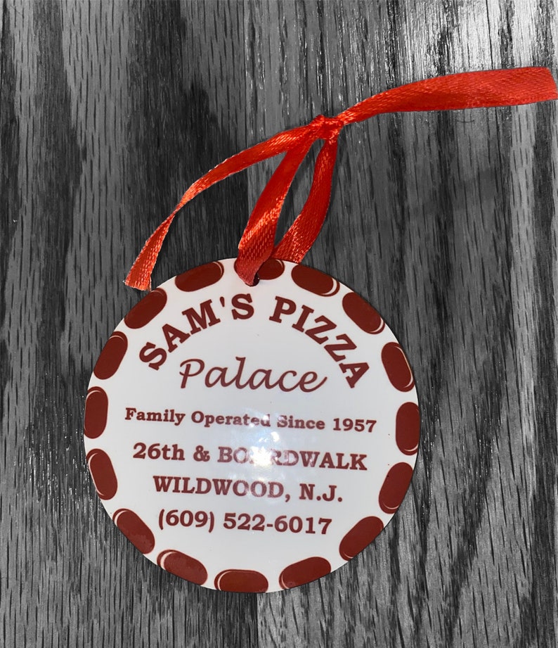 May include: A white round sign with red polka dots and the text "SAM'S PIZZA Palace Family Operated Since 1957 26th & BOARDWALK WILDWOOD, N.J. (609) 522-6017".
