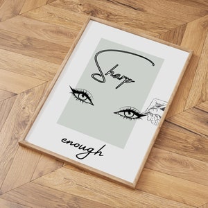 May include: A framed print with a light green background featuring a stylized illustration of an eye with eyelashes and the text "Sharp enough".