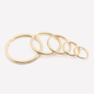May include: Set of six gold-toned key rings of varying sizes.