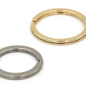 May include: Two key rings, one gold and one silver, both with a double ring design.