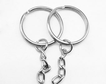 May include: Two silver key rings with attached chains. The key rings are linked together.