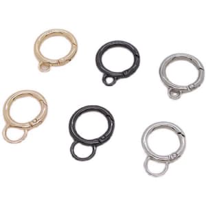 May include: Six metal key rings in different finishes: gold, black, and silver. Each ring has a swivel clasp and a small loop for attaching keys or other items.