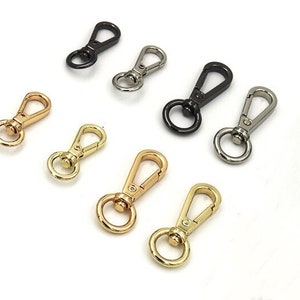 May include: Assortment of seven metal swivel clasps in gold, silver, and black finishes. The clasps are a popular choice for attaching straps, chains, or other accessories to bags, purses, and other items.