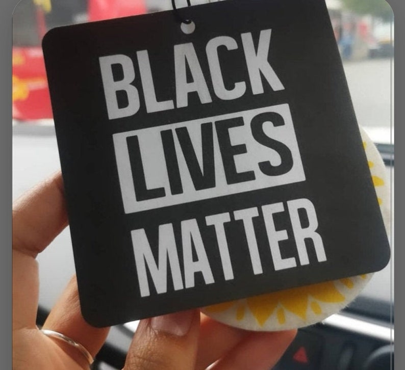 May include: Black and white car air freshener with the text "Black Lives Matter" in white letters on a black background.