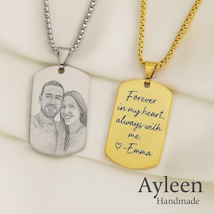 May include: Two dog tag necklaces. One is silver with a sketched portrait of a couple. The other is gold with the inscription "Forever in my heart, always with me. -Emma". Both hang on a chain.