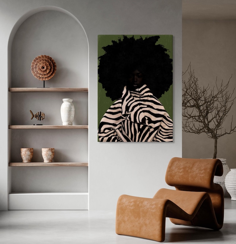 Op de afbeelding: Een kunstafdruk met een persoon met een grote afro en een jas met zebraprint tegen een groene achtergrond. Het kunstwerk wordt getoond in een modern interieur met een bruine leren stoel en decoratieve planken.