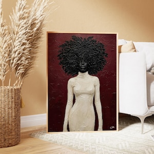 May include: A framed painting of a Black person with a large, textured afro. The figure wears a long-sleeved, off-white turtleneck dress against a deep red background. The artwork is displayed in a room with neutral tones.