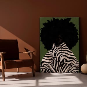 Op de afbeelding: Een kunstafdruk met een persoon met een grote afro en een jas met zebraprint. Het kunstwerk staat tegen een groene achtergrond, met een bruine stoel en een decoratieve vaas op de voorgrond.