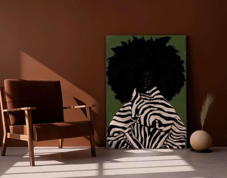 Op de afbeelding: Een kunstafdruk met een persoon met een grote afro en een jas met zebraprint. Het kunstwerk staat tegen een groene achtergrond, met een bruine stoel en een decoratieve vaas op de voorgrond.