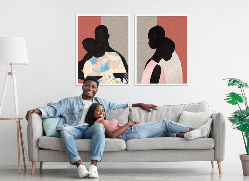 May include: Two framed wall art prints featuring black silhouettes of figures against a background of muted red and beige. The left print shows a figure carrying another, while the right print depicts two figures in profile, all with textured patterns.