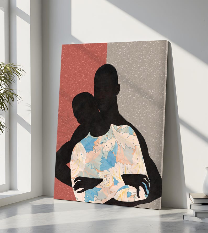 May include: A rectangular wall art print featuring the black silhouettes of two figures embracing. One figure wears a shirt with a light blue, peach, and white floral pattern. The background is split vertically between a textured terracotta and grey.