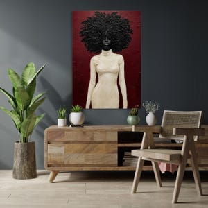 May include: An oil painting depicts a Black figure with a large, textured afro and a cream-colored turtleneck dress against a deep red background. The artwork is displayed above a wooden cabinet with a plant and decorative items.