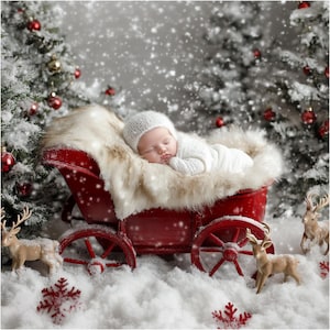 Puede incluir: Un bebé durmiendo en un vagón rojo con forro de piel sintética, vistiendo un conjunto y gorro de punto blanco. La escena está ambientada en un país de las maravillas invernal nevado con árboles de Navidad y figuras de renos.