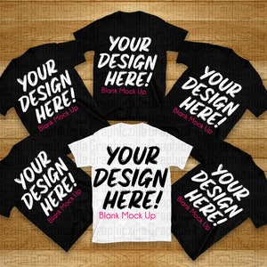 Puede incluir: Cinco camisetas, cuatro negras y una blanca, dispuestas sobre una superficie de madera. Cada camiseta tiene el texto "Your Design Here! Blank Mock Up" impreso en blanco en la parte delantera.