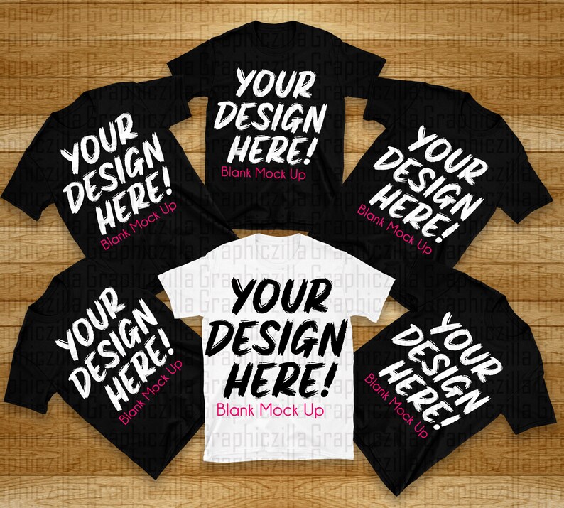 Puede incluir: Cinco camisetas, cuatro negras y una blanca, dispuestas sobre una superficie de madera. Cada camiseta tiene el texto "Your Design Here! Blank Mock Up" impreso en blanco en la parte delantera.