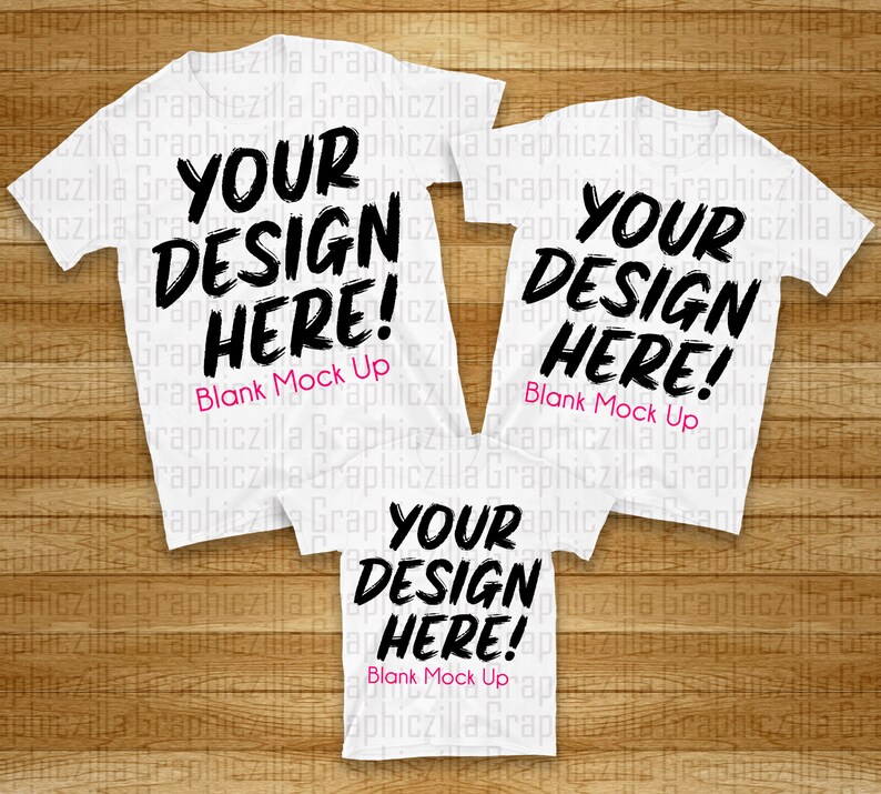 Puede incluir: Tres camisetas blancas con el texto "YOUR DESIGN HERE! Blank Mock Up" impreso en ellas. Las camisetas est&aacute;n dispuestas en forma de pir&aacute;mide sobre una superficie de madera.