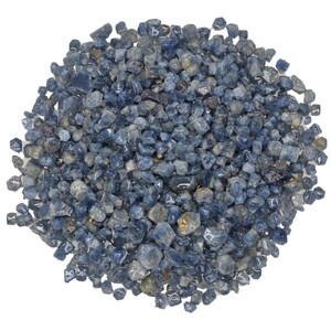 May include: A pile of small, rough, blue sapphire gemstones. The gemstones are various shades of blue and have a slightly translucent appearance.