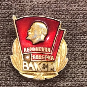 May include: A gold and red enamel pin with a profile of Lenin, a red flag, and the text "LENINSKAYA POVYERKA VAKSM".