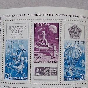 May include: A set of three Soviet postage stamps commemorating the return of lunar soil to Earth. The stamps feature a blue and white illustration of a spacecraft, a blue and white illustration of a parachute, and a silver and white illustration of a lunar module. The stamps are dated 1970 and feature the text "CCCP" and "ПОЧТА 1970".