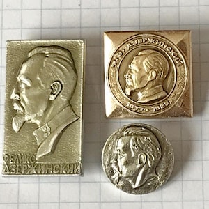 Peut inclure: Trois épingles métalliques vintage représentant un profil d'homme barbu. Les épingles sont de forme rectangulaire, carrée et circulaire. L'épingle rectangulaire porte le nom "FELIKS DZERZHINSKY". L'épingle carrée porte les années "1877-1926".