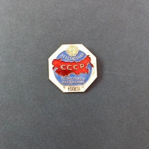 May include: A red, white and blue enamel pin with a map of the USSR and the text "Всесоюзная Перепись Населения 1989" (All-Union Census of the Population 1989).