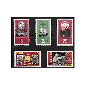 May include: A white ceramic mug with a black handle and the text "But First, Coffee" in a black, handwritten-style font. The mug is on a white surface.