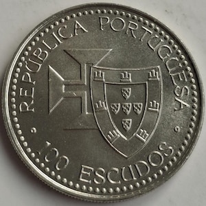 Puede incluir: Una moneda de plata de 100 escudos de Portugal. La moneda presenta las palabras "REP&Uacute;BLICA PORTUGUESA" y "100 ESCUDOS" alrededor del borde. El centro de la moneda tiene un escudo y un dise&ntilde;o en forma de cruz.