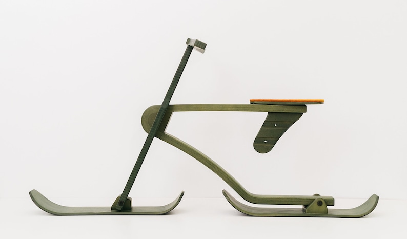 以下が含まれることがあります： 緑色の塗装が施された木製のおもちゃのそりで、オレンジ色の座席が付いています。そりはハンドルと2本のスキーが付いています。