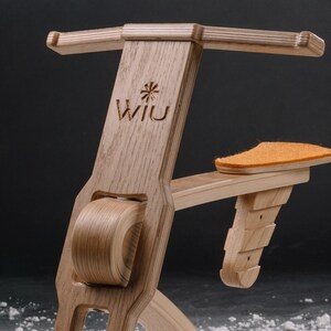 以下が含まれることがあります： 木製の自転車の形をしたおもちゃで、茶色の革製のシートと前面に「Wii U」という文字が刻まれています。